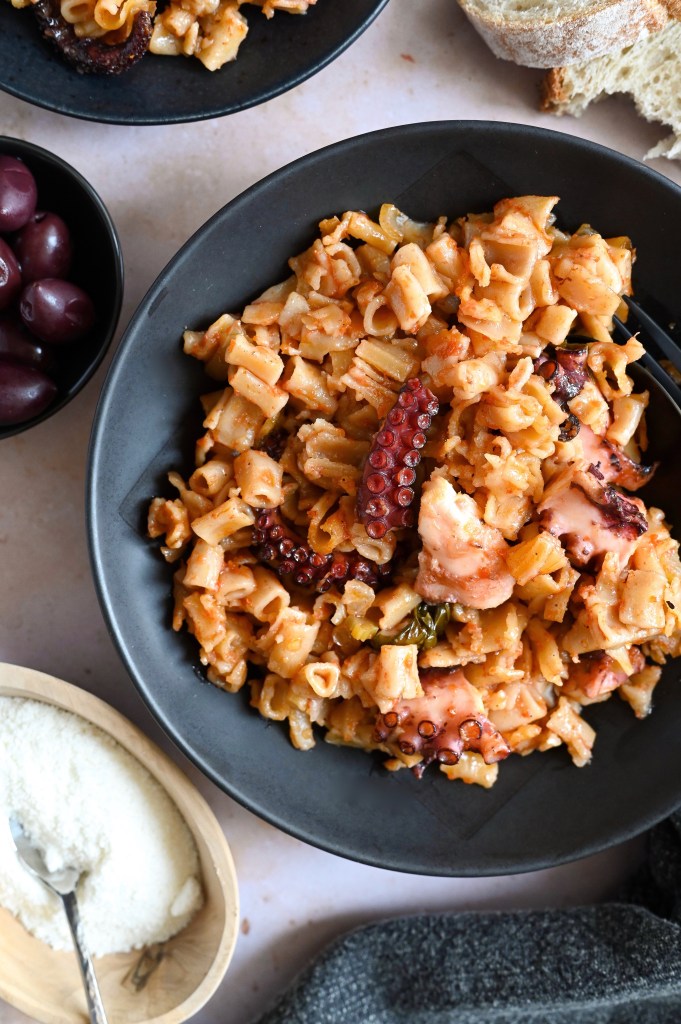 Greek recipe for octopus in a tomato sauce and small shaped pasta, baked in the oven.