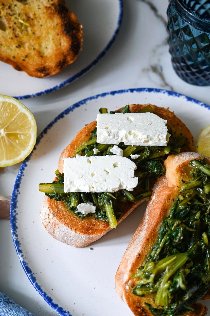 An open-face sandwich of dandelion greens and grilled bread flavoured with lemon, olive oil, garlic, oregano and feta
