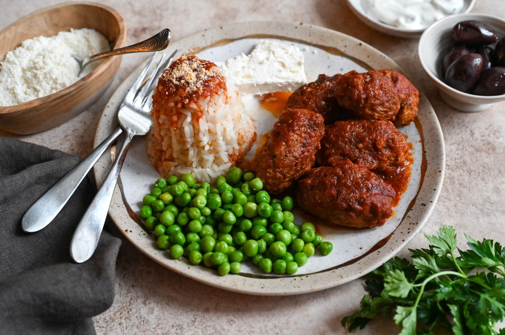 Soutzoukakia, a cross between burgers and meatballs, served in a rich tomato sauce and rice.