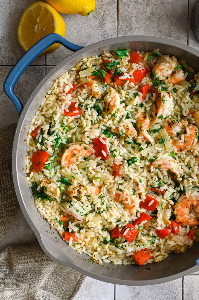 A one skillet meal of shrimps and rice full of vegetables and herbs.