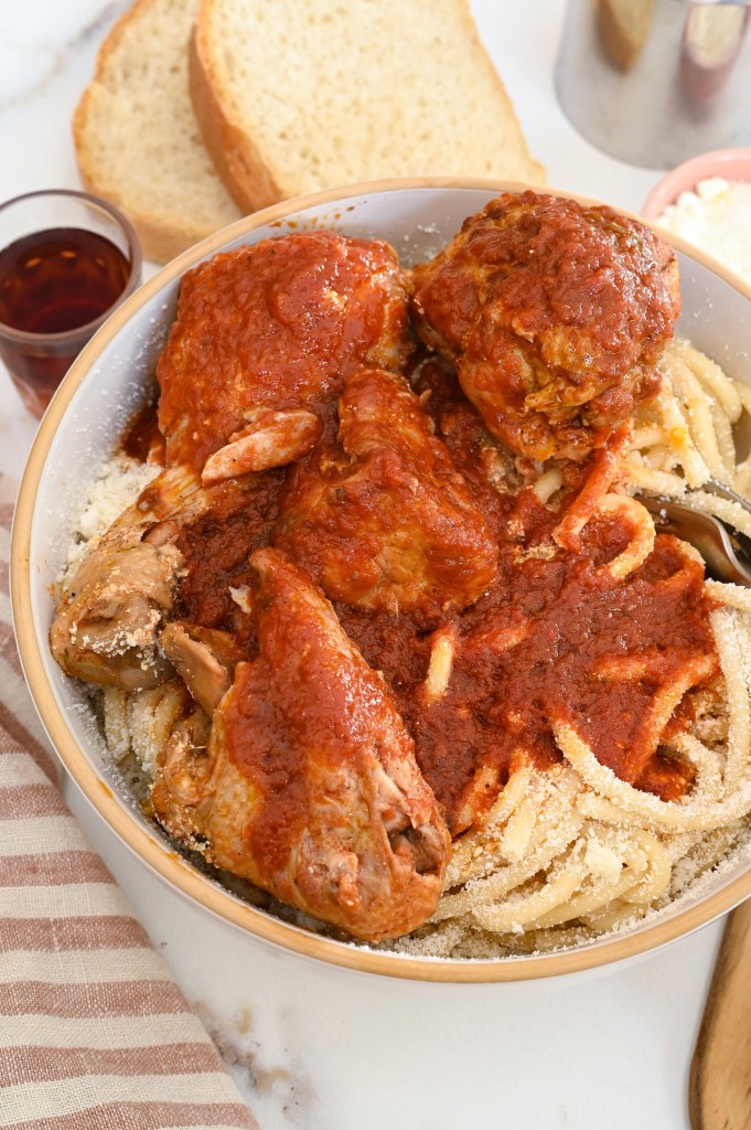 Traditional Greek recipe of rooster with pasta and rich tomato sauce or Kokora me makaronia.