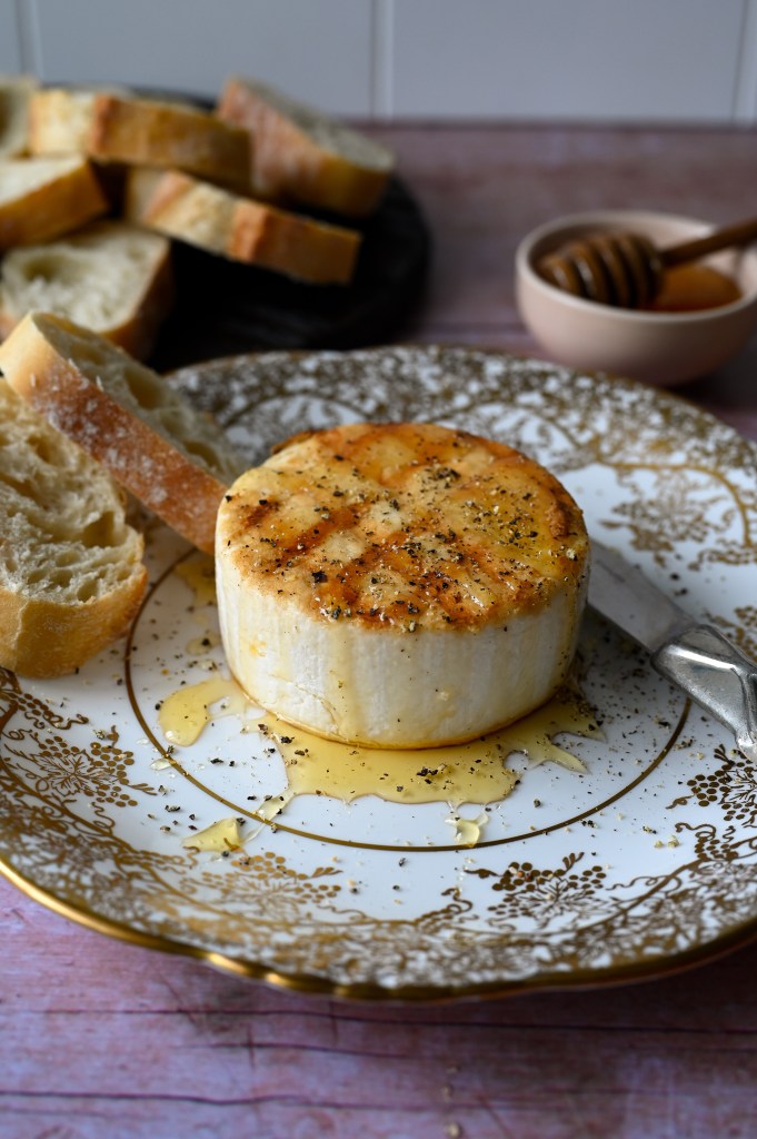 Greek meze of grilled manouri cheese drizzled with honey and topped with cracked black pepper.